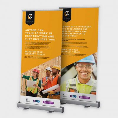 two orange pull up banners with photos of builders and logos two orange pull up banners with photos of builders and logos